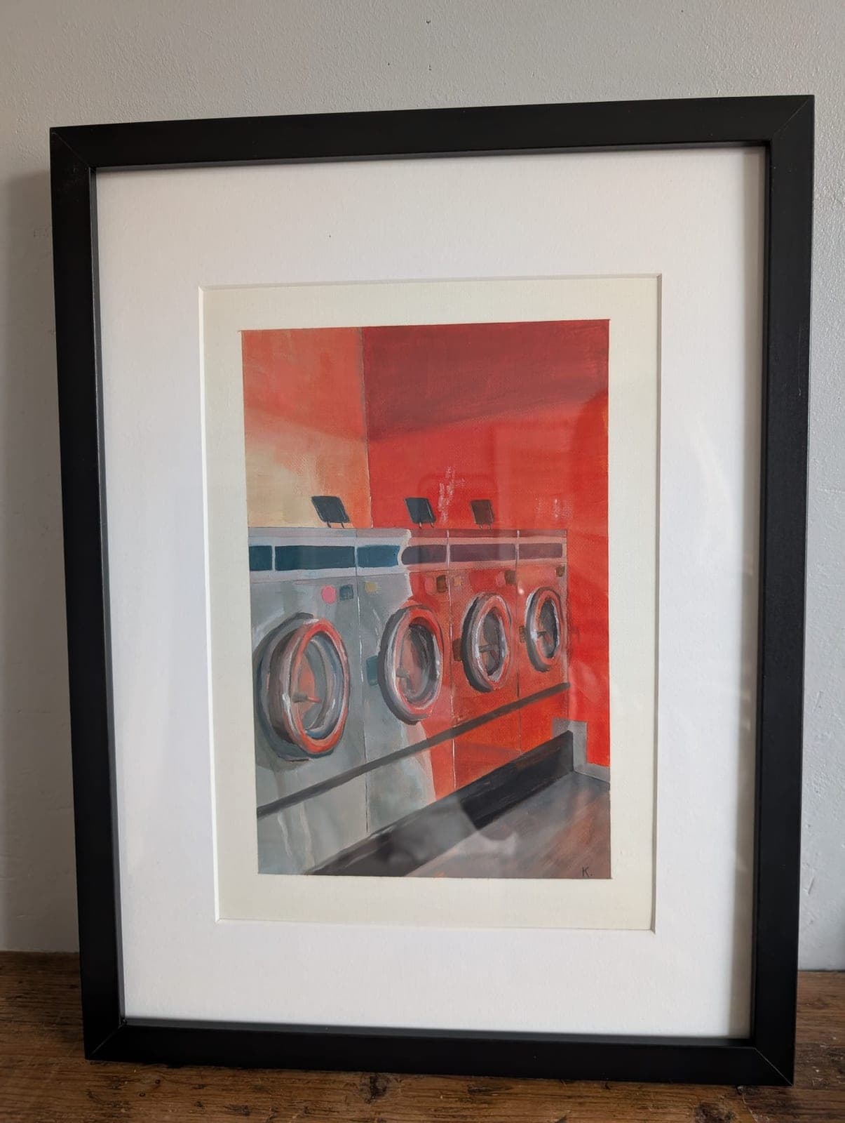 Mounted and framed, leaning against a wall